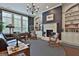 Living room with built-in bookshelves surrounding fireplace, rocking chairs, and a large window at 208 Cottonwood Cir, Peachtree City, GA 30269