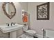 Charming powder room featuring a pedestal sink, decorative mirror, and tasteful wall art at 208 Cottonwood Cir, Peachtree City, GA 30269