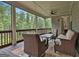 Relaxing screened porch with wicker furniture, ceiling fan, and beautiful views of the surrounding trees at 208 Cottonwood Cir, Peachtree City, GA 30269