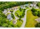 Aerial view of neighborhood streets lined with manicured lawns, lush landscaping, and community tennis courts at 101 Deer Park Dr, Carrollton, GA 30116