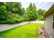 Spacious backyard featuring a lush lawn, complemented by a pristine white fence and mature trees at 101 Deer Park Dr, Carrollton, GA 30116