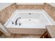 Bathroom showcasing a corner jetted tub with tile surround and countertop at 101 Deer Park Dr, Carrollton, GA 30116