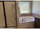 Well-lit bathroom featuring a soaking tub, separate shower, and tiled wall accents at 101 Deer Park Dr, Carrollton, GA 30116