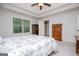 Bedroom boasts neutral tones, tray ceilings, ceiling fan, and ample natural light from a window at 101 Deer Park Dr, Carrollton, GA 30116
