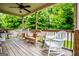 Relaxing covered deck featuring wicker furniture, offering a comfortable outdoor living space with a ceiling fan at 101 Deer Park Dr, Carrollton, GA 30116