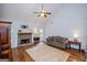 Open living room features a stone fireplace, ceiling fan, and hardwood floors at 101 Deer Park Dr, Carrollton, GA 30116