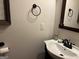 Powder room with a pedestal sink, decorative mirror, and simple, clean design at 101 Deer Park Dr, Carrollton, GA 30116