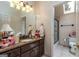 A bathroom shows a granite sink and shower with glass door, along with white cabinets at 675 Falls Lake Dr, Alpharetta, GA 30022