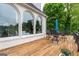 Charming deck adjacent to the house features views of the verdant property and elegant arched windows at 675 Falls Lake Dr, Alpharetta, GA 30022