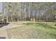 Large, grassy backyard with a storage shed surrounded by mature trees offers privacy at 1967 Levgard Ln, Riverdale, GA 30296