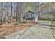 Charming two-story home with gray siding, surrounded by mature trees and a long driveway at 1967 Levgard Ln, Riverdale, GA 30296