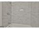 Shower featuring stylish gray tiled walls with a sleek, modern shower head and fixtures at 1967 Levgard Ln, Riverdale, GA 30296