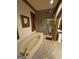 Close up of an elegant soaking tub and glass enclosed shower in a bathroom with tile floors at 275 Old Mill Ct, Fayetteville, GA 30214