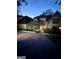 Exterior of a home at night with a brick driveway and decorative landscaping at 275 Old Mill Ct, Fayetteville, GA 30214