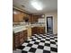 Kitchen with checkered floors, white backsplash and wooden cabinets at 953 South Ave, Forest Park, GA 30297