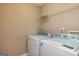 This laundry room boasts a modern washer and dryer set with a wire rack shelf above for convenient storage at 2786 Snapfinger Mnr, Decatur, GA 30035