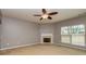Cozy living room features a fireplace, a ceiling fan, and a large window at 2786 Snapfinger Mnr, Decatur, GA 30035