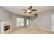 Cozy living room features a fireplace, a ceiling fan, and a large window at 2786 Snapfinger Mnr, Decatur, GA 30035