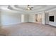 Large carpeted main bedroom featuring a tray ceiling with decorative beams and a ceiling fan at 5905 Langdale Chase # 17, Douglasville, GA 30135