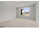 Bedroom showcasing neutral walls, soft carpeting, and a window with neighborhood views at 6600 Wansfell Ct # 28, Douglasville, GA 30135