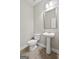 This powder room offers a pedestal sink, a square mirror, and tile flooring at 6600 Wansfell Ct # 28, Douglasville, GA 30135