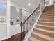 Carpeted staircase with dark wood railing, leading to a bright, open living space at 6600 Wansfell Ct # 28, Douglasville, GA 30135