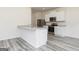 Modern kitchen with white cabinets, stainless steel appliances, granite countertops, and light gray wood floors at 287 Limestone Circle, Conyers, GA 30013