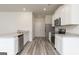 Modern kitchen featuring white cabinets, stainless steel appliances, granite countertops, and light gray wood floors at 287 Limestone Circle, Conyers, GA 30013