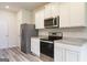 Bright kitchen features stainless steel appliances, granite countertops, and white cabinets at 287 Limestone Circle, Conyers, GA 30013