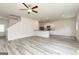 Open-concept living room featuring light gray wood floors, ceiling fan, and a view of the kitchen at 287 Limestone Circle, Conyers, GA 30013