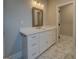 Bathroom featuring white vanity with drawers, elegant countertop, and patterned tile flooring at 5118 N Pratt St, Covington, GA 30014