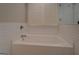 Bathroom tub with white subway tiles, window with plantation shutters, and designer floor at 5118 N Pratt St, Covington, GA 30014