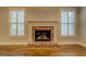 Cozy fireplace with detailed brickwork, flanked by windows with views, set on gleaming hardwood floors at 5118 N Pratt St, Covington, GA 30014