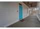 Inviting covered front porch featuring a stylish wood ceiling and a bright blue front door at 5118 N Pratt St, Covington, GA 30014