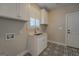 Mudroom with white cabinets, sink, and patterned floor tiles at 5118 N Pratt St, Covington, GA 30014