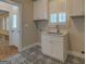 Mudroom featuring white cabinets, utility sink, and decorative tile flooring at 5118 N Pratt St, Covington, GA 30014