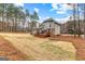 Backyard view of the home showcasing a spacious lawn and large wooden deck for outdoor living at 115 Wellborn Chase, Fayetteville, GA 30215