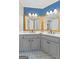Bathroom featuring dual sinks, tiled floors, vanity lighting and a decorative mirror at 115 Wellborn Chase, Fayetteville, GA 30215