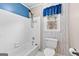 Bright bathroom showcasing a shower-tub combo, tiled floors, and a toilet at 115 Wellborn Chase, Fayetteville, GA 30215