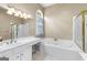 Well-lit bathroom with dual sinks, shower, and soaking tub for relaxing at 115 Wellborn Chase, Fayetteville, GA 30215
