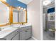 Bathroom featuring dual sinks, tiled floors, vanity lighting and a decorative mirror at 115 Wellborn Chase, Fayetteville, GA 30215