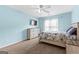 Bedroom featuring pastel blue walls, a flat screen TV, dresser, ceiling fan and floral bedding at 115 Wellborn Chase, Fayetteville, GA 30215