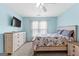 Well-lit bedroom featuring light blue walls and a cozy queen-size bed with floral bedding at 115 Wellborn Chase, Fayetteville, GA 30215