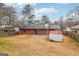 A wide view of backyard showing the patio, storage building, fencing and the brick home at 979 Walnut Creek Ln, Jonesboro, GA 30238