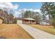 Inviting single-story brick home with a long driveway, attached garage, a cozy front porch, and a spacious front yard at 979 Walnut Creek Ln, Jonesboro, GA 30238