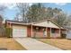 Charming single-story brick home featuring an attached garage, a welcoming front porch, and a well-maintained lawn at 979 Walnut Creek Ln, Jonesboro, GA 30238