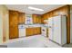 Bright kitchen featuring wood cabinets, white appliances and a double sink at 979 Walnut Creek Ln, Jonesboro, GA 30238