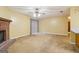 Spacious living room featuring a brick fireplace, neutral carpeting, a ceiling fan, and sliding glass doors to the backyard at 979 Walnut Creek Ln, Jonesboro, GA 30238