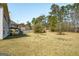 Large backyard with lush trees, a small red barn, and stairs leading to a deck at 1421 Saint Charles Ct, Conyers, GA 30094