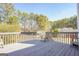 A wood deck surrounded by a lush green landscape, with a chair for relaxation at 1421 Saint Charles Ct, Conyers, GA 30094